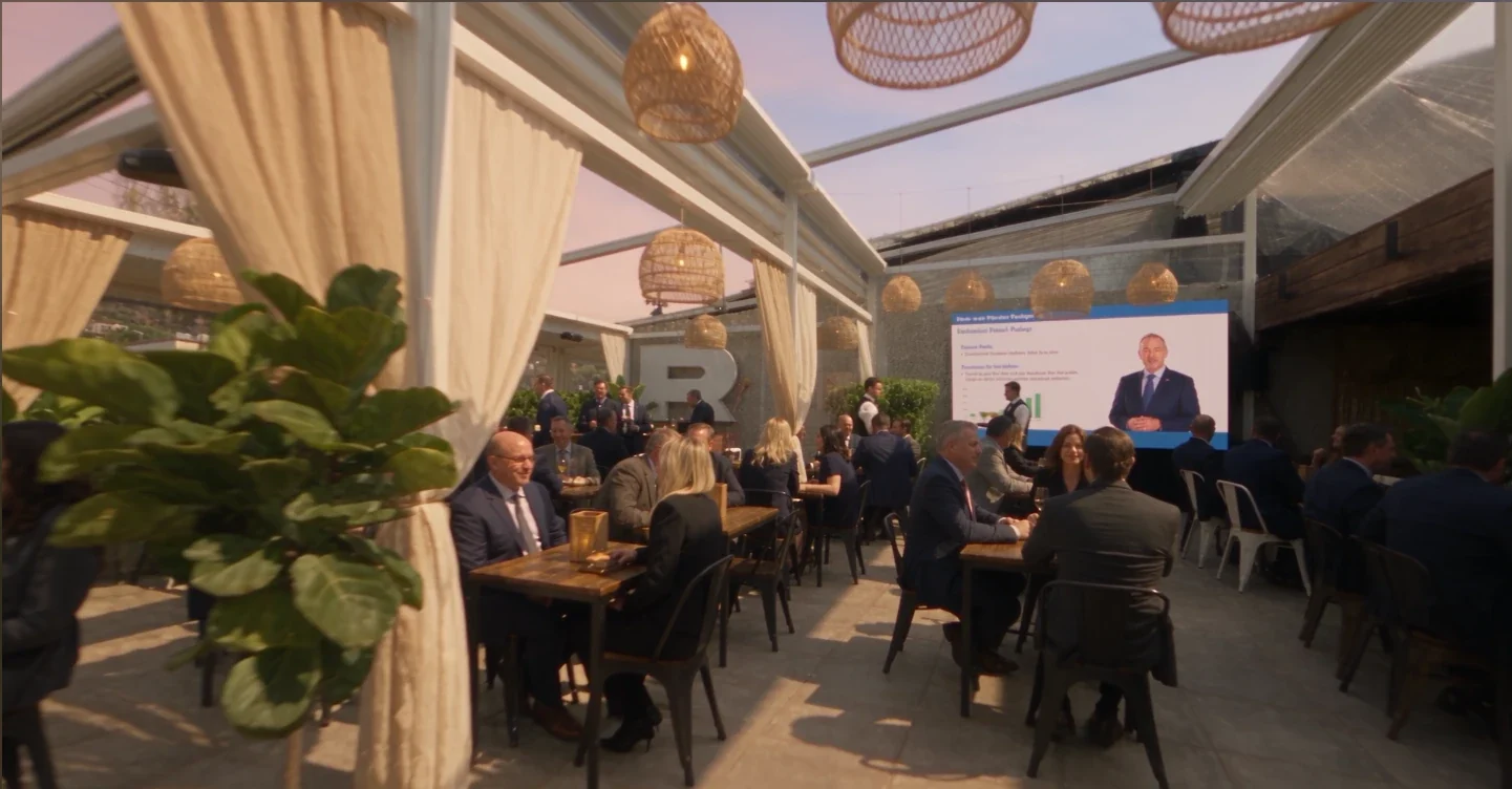 Evento corporativo en la terraza de Roatán, con una presentación en la pantalla gigante